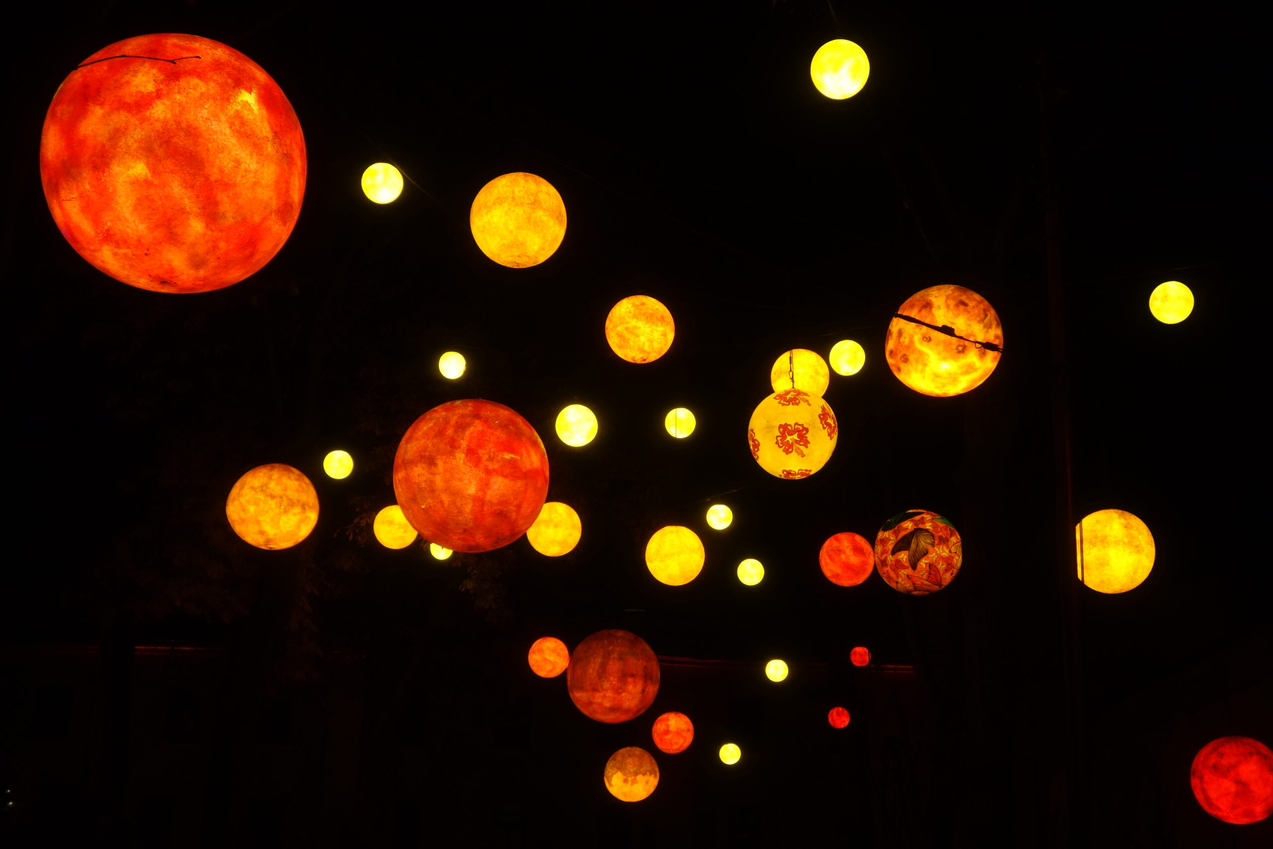 Foto einer Lichterkette mit unterschiedlich bemalten und dekorierten Lichtkugeln